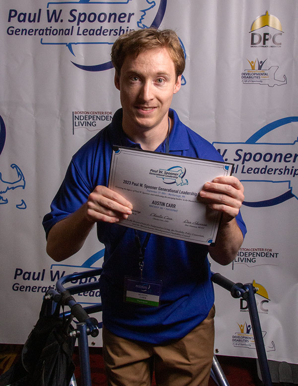 A young man holding a participation certificate.