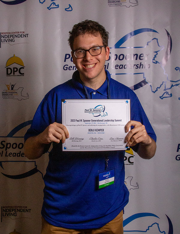 A young man holding a participation certificate.