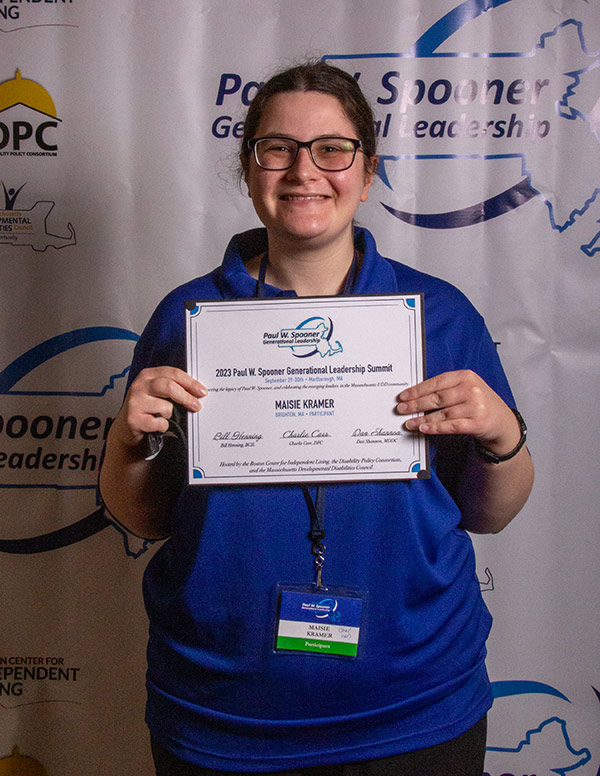 A young woman holding a participation certificate.